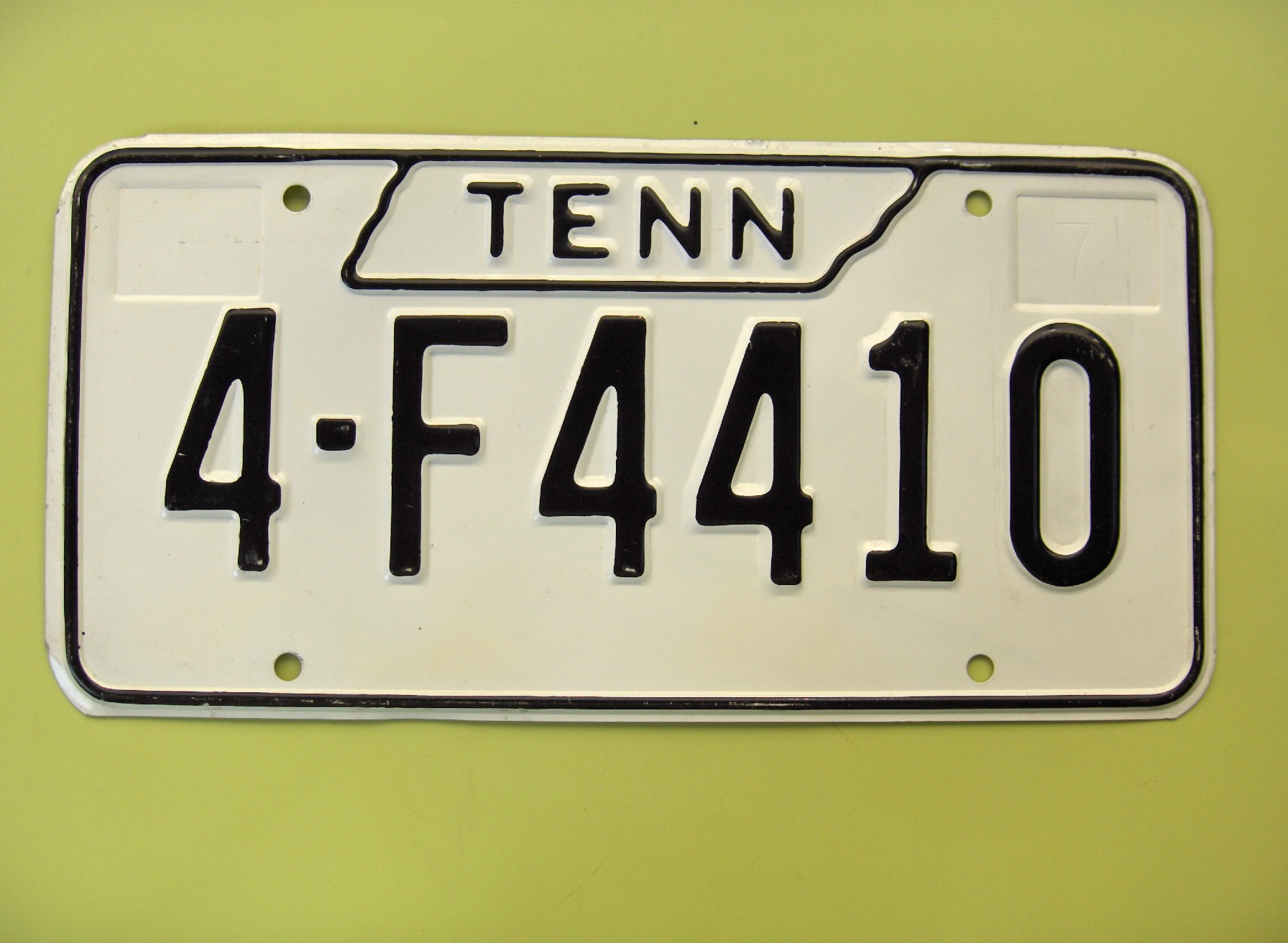 TN_1971-1977_TYPE1_DATED_WITH_CURVED-7-_LARGE_NAME_INSIDE_LARGE_STATE-SHAPED_BORDER_MADE_IN_STEEL_FB